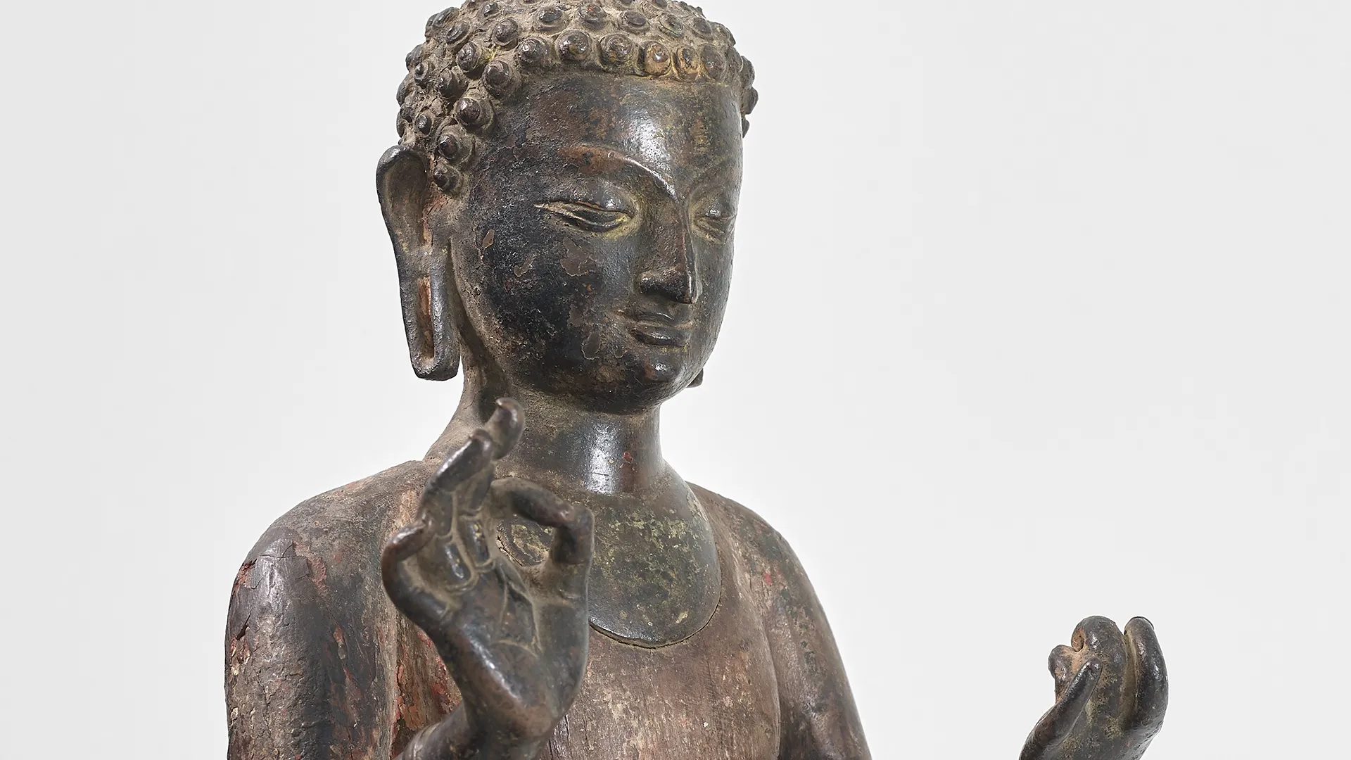 A copper and wood figure of Dipankara Buddha