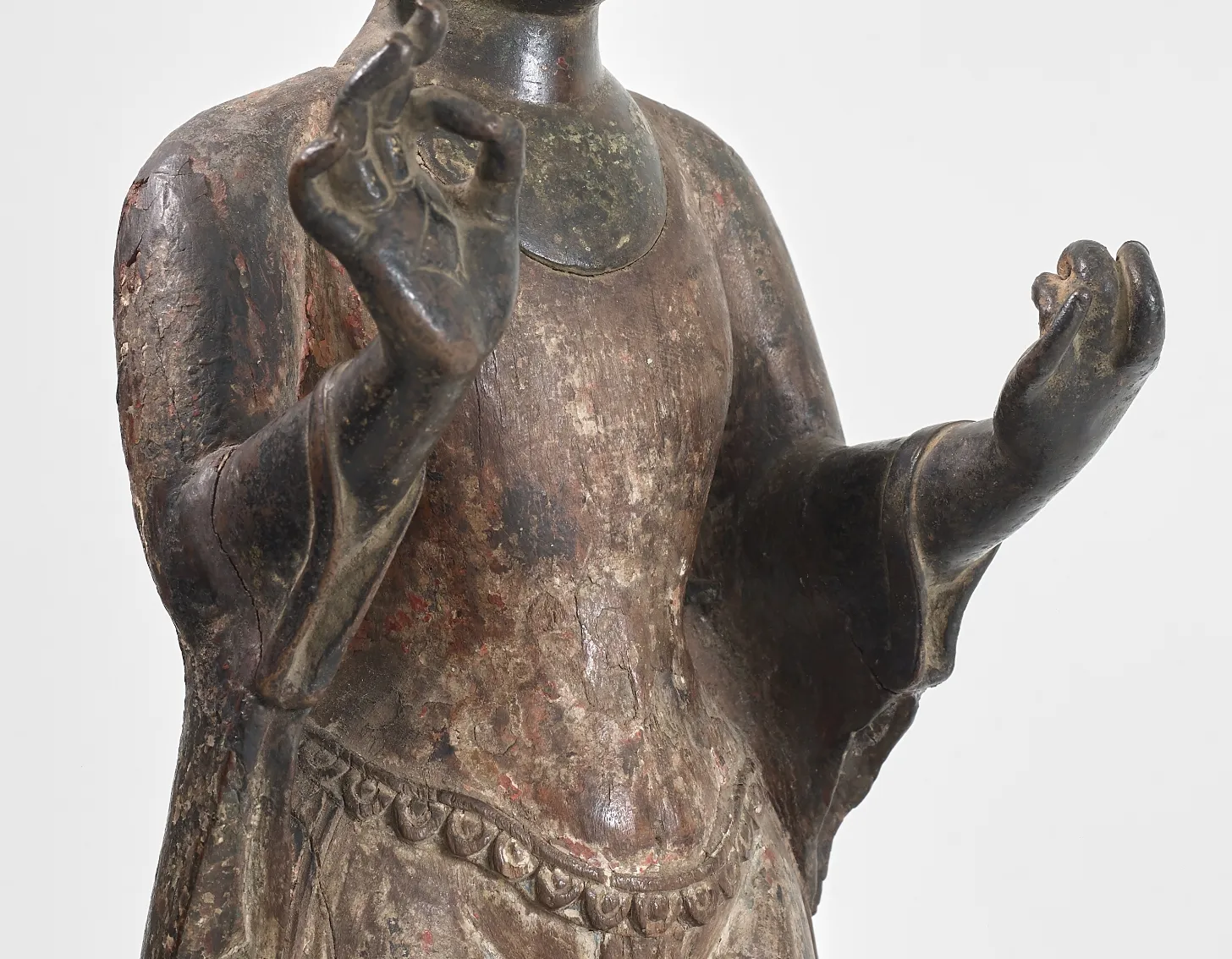 Close up look of : A copper and wood figure of Dipankara Buddha